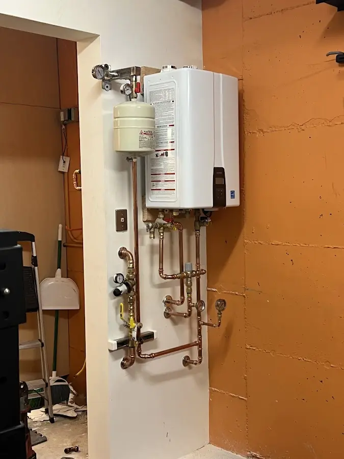 Plumbing technician inspecting water heater connections in Ball Ground